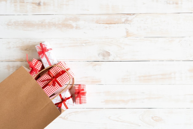 Einkaufstasche und Geschenkbox auf einem hölzernen weißen Hintergrund. Boxing Day Konzept.