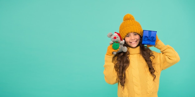 Einkaufstipps Ratte Symbol des Jahres Glückliches Mädchen hält Maus Spielzeug und verpackte Geschenkbox Kind Strickpullover und Mütze spielen Plüschtier Shop für Kinder Frohes Jahr 2020 Geschenk für Glück Beschwichtigen Sie mit Geschenk