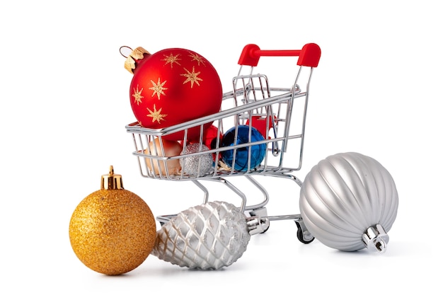 Einkaufswagen mit Weihnachtsschmuck auf weißem Hintergrund