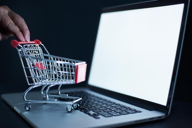 Einkaufswagen oder Trolley vor Laptop-Online-Marketing und Business-Trading-Konzept