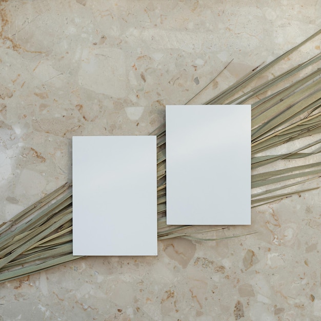 Foto einladungskarten aus leerem papier mit kopierraum. getrockneter tropischer palmenblattstiel auf marmorsteinhintergrund. flache, draufsicht, ästhetische, minimalistische hochzeitseinladungen