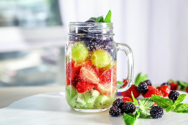 Einmachglas mit Beerenwasser auf dem Tisch