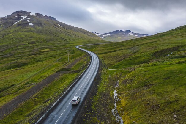 Einsame Fahrt mit dem Mietwagen auf einer abgelegenen Straße mit wunderschöner Landschaft Islands