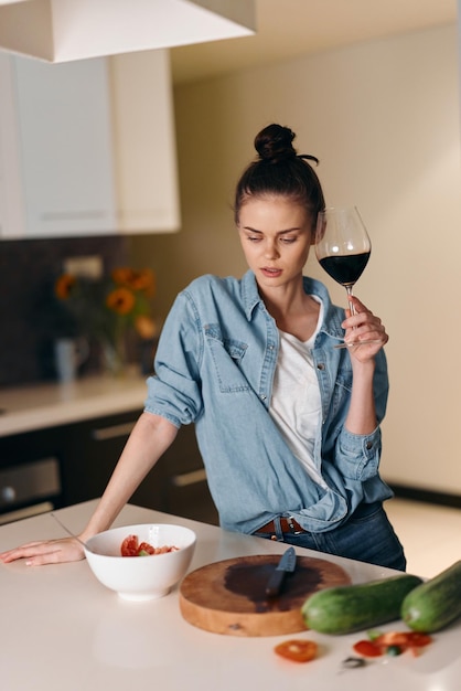 Einsame Frau in einer weißen Küche mit einem Weinglas fühlt Verzweiflung und Einsamkeit