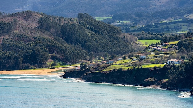 Einsame Strände im Norden Spaniens mit Häusern in den grünen Feldern neben den Bergen Lastres Asturias