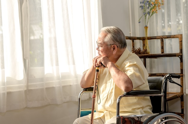 Einsamer asiatischer Senior war krank und saß im Rollstuhl. Rentenalter Lebensstil und allein zu Hause bleiben.