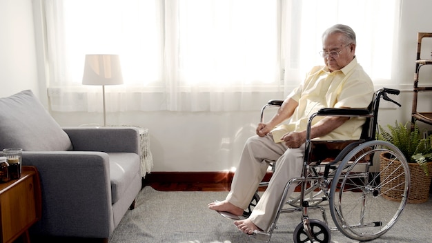 Einsamer asiatischer Senior war krank und saß im Rollstuhl. Rentenalter Lebensstil und allein zu Hause bleiben.