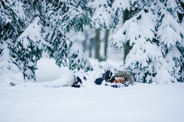 Einsamer Mann, der im verschneiten Wald schläft