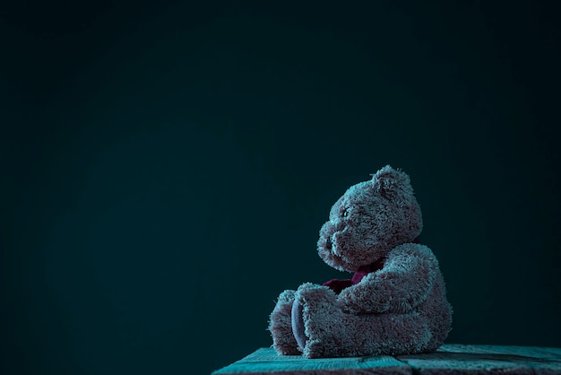 Einsamer Teddybär auf dunklem Hintergrund