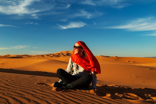 Einsames Mädchen in der Sahara-Wüste bei Sonnenuntergang. Erg Chebbi, Merzouga, Marokko.