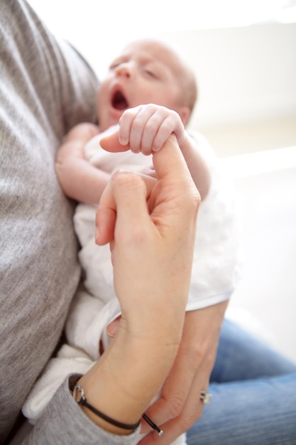 Einschlafen in den Armen ihrer Mutter Aufnahme eines neugeborenen Mädchens, das von ihrer Mutter gehalten wird