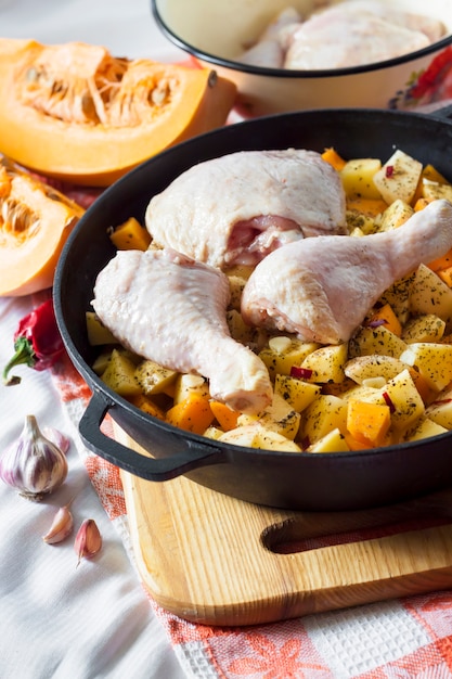 Foto eintopfgericht kochen - hähnchenschenkel und beine mit kartoffeln und kürbis