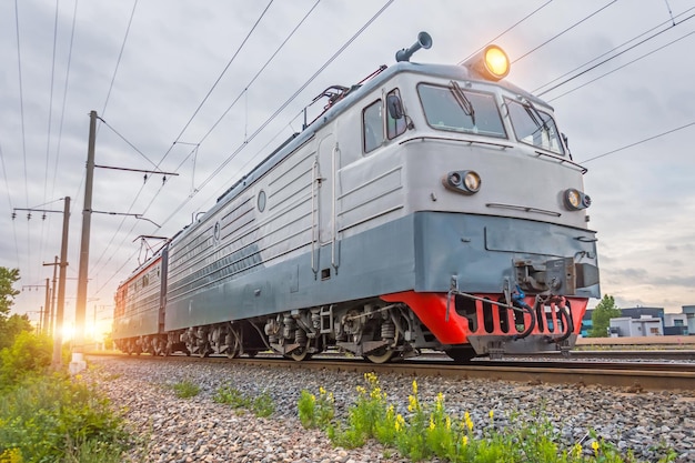 Einzelne Elektrolokomotive auf der Eisenbahn abends bei Sonnenuntergang