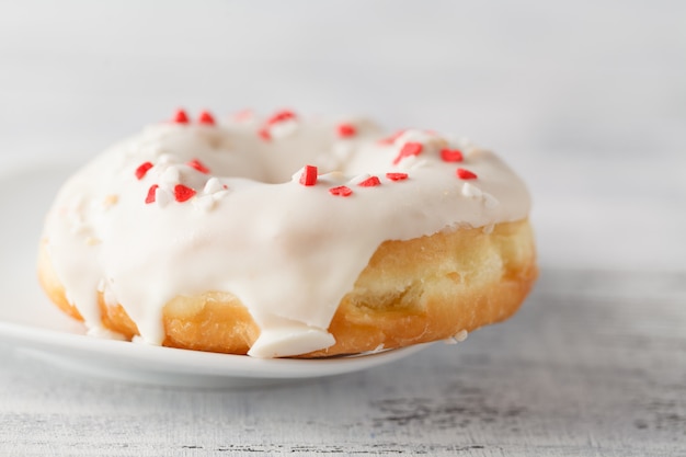 Einzelner Donut auf weißem Teller