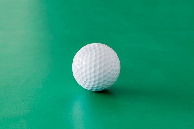 Einzelner Golfball auf dem grünen Hintergrund