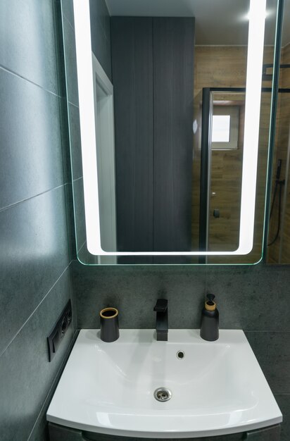 Einzelnes weißes Handwaschbecken, Waschtisch und Spiegel in einem Badezimmer