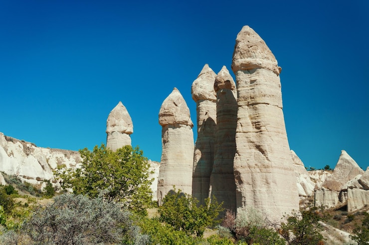 Foto einzigartige geologische formationen im love valley in kappadokien vor blauem himmel im sommer. beliebtes touristengebiet in göreme nevsehir, türkei