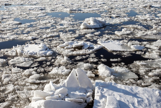 Eis auf dem Fluss, Eisdrift auf dem Reservoir, geteilte Stücke von gefrorenem Wasser, das auf dem Wasser schwimmt