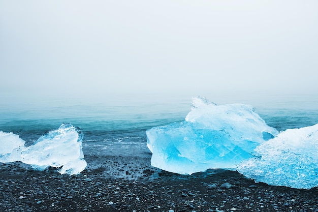 Eis auf dem schwarzen Vulkansand. Eisstrand Jokulsarlon, Südisland. Selektiver Fokus