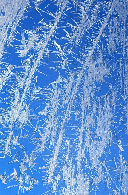 Eis auf einem Fenster blau-weißes vertikales Foto