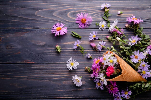 Eis aus Blumen in einem Waffelbecher auf einem hölzernen Hintergrund mit Platz für Text