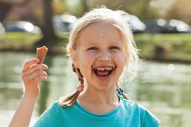 Eis bringt Spaß für Kinder Glückliches Kind, das Eiscremekegel isst Glückliches Kindergesicht