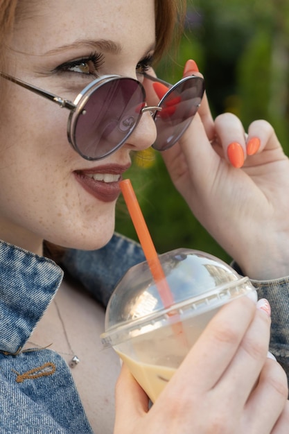 Eis-Latte-Kaffee in weiblicher Hand im Freien