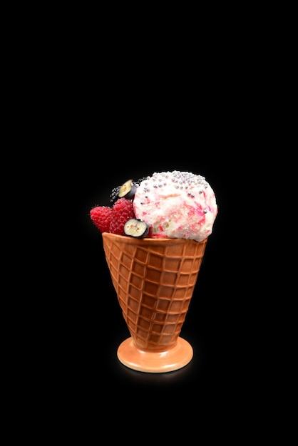 Eis mit Blaubeeren, Brombeeren und Himbeeren auf einer schwarzen Oberfläche