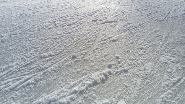Eis mit der Spitze von Eiskunstlaufstreifen Eiskunstlauf auf Eis Die Oberfläche der Eisbahn, nachdem die Skater Sunbeam auf nassem Frühlingseis ausüben Schnee und gefrorenes Wasser