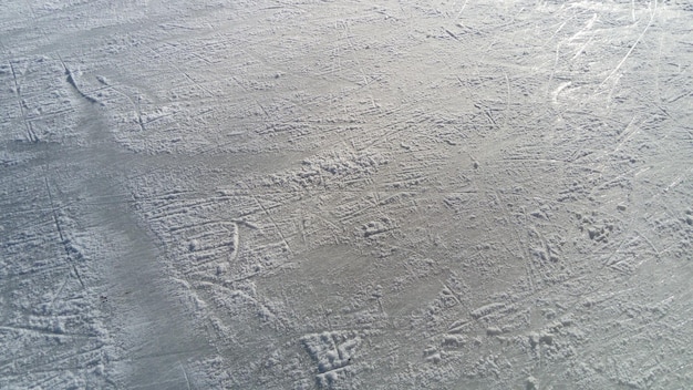 Eis mit der Spitze von Eiskunstlaufstreifen Eiskunstlauf auf Eis Die Oberfläche der Eisbahn, nachdem die Skater Sunbeam auf nassem Frühlingseis ausüben Schnee und gefrorenes Wasser