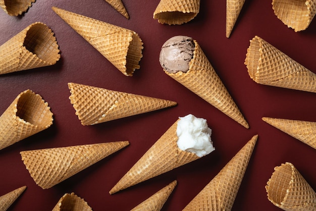 Eis und Waffel leere Eistüten auf braunem Hintergrund flach gelegt