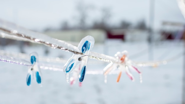 Eisbedeckte Wäscheklammern am Seil