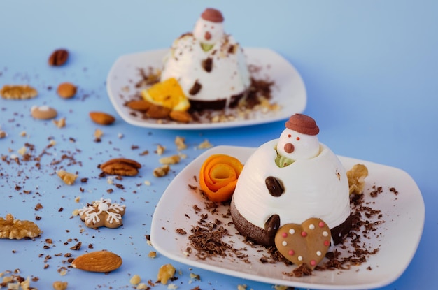 Eiscreme-Hintergrund in Form von zwei essbaren Schneemännern auf weißen Platten aus nächster Nähe. Ansicht von oben. Dessert