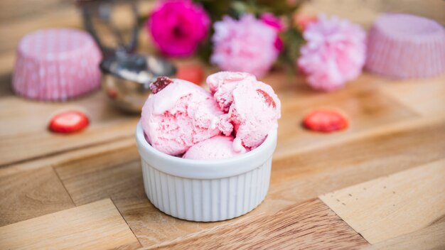 Foto eiscreme in der schüssel nahe scheiben von frischen beeren und von blumen