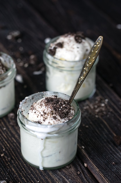 Eiscreme mit Schokoladenplätzchen in den Glasgefäßen. Rustikaler Stil.