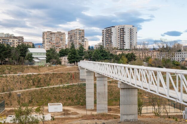 Eisen-Fußgängerbrücke über einen in Weiß bemalten kleinen Schlucht in Tbilisi, Georgien