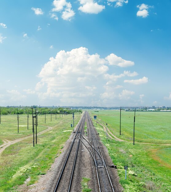 Eisenbahn in grüner Landschaft unter Wolken