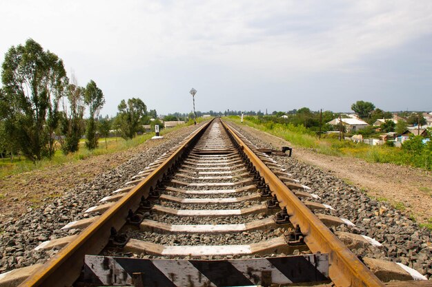 Eisenbahn über dem Horizont Eisenbahnschienen und Betonschwellen vor dem Hintergrund einer ländlichen Gegend