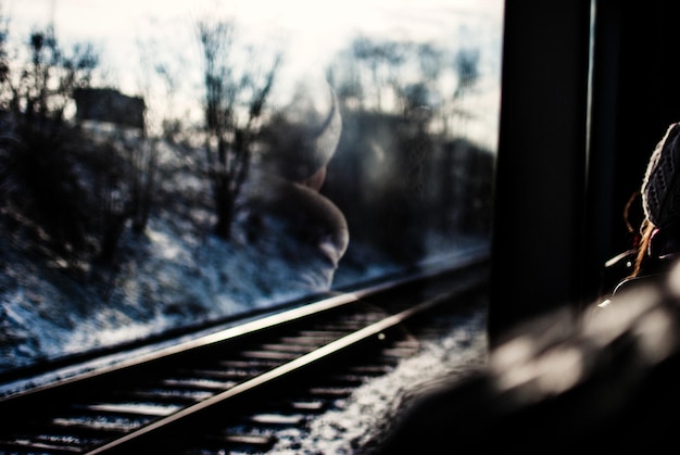 Foto eisenbahnschiene, die im winter durch das zugfenster mit reflexion gesehen werden