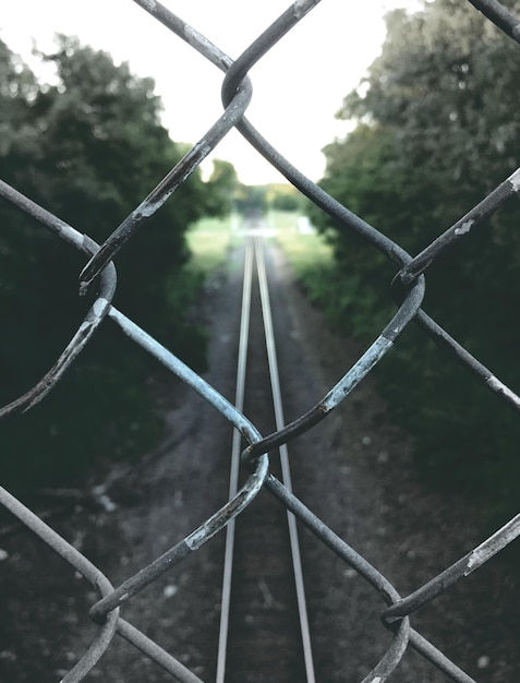 Foto eisenbahnschiene durch einen kettengrenz gesehen