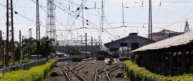 Eisenbahnschienen inmitten von Bäumen und Gebäuden gegen den Himmel