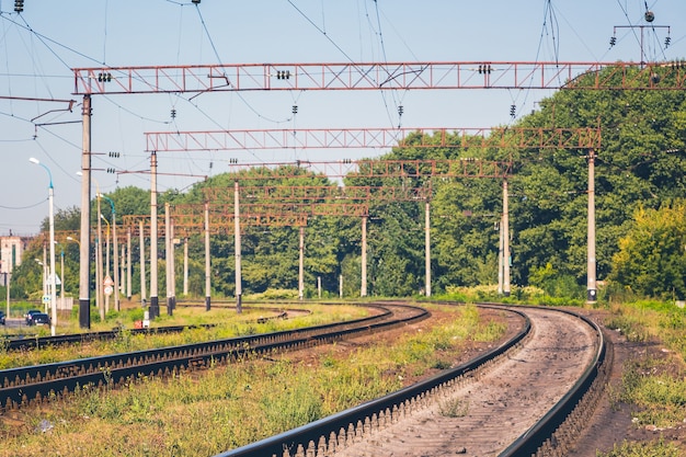 Eisenbahnschienen moderner elektrifizierter Eisenbahnen in der Nähe des Waldes