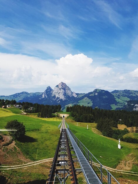 Foto eisenbahnstrecke inmitten des feldes gegen den himmel