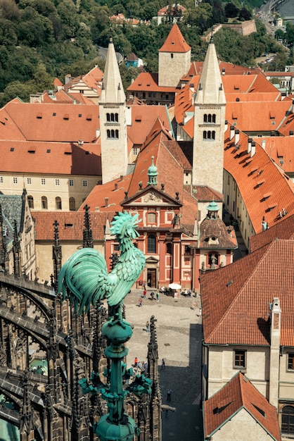 Eisenhahnfigur oben auf der Veitskathedrale mit Blick auf die roten Ziegeldächer der Stadt in Prag, Tschechische Republik