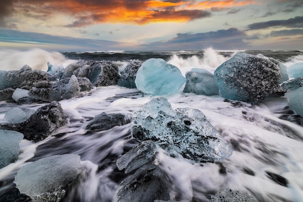 Eisfelsen und schwarzer Sand am Jokulsarlon-Strand bei Sonnenuntergang Diamond Beach im Südosten Islands