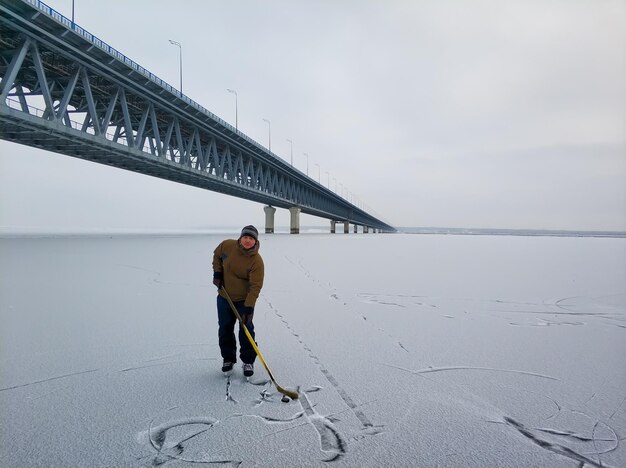 Eishockeyspieler an der Wolga vor der Kulisse einer großen Brücke in Uljanowsk