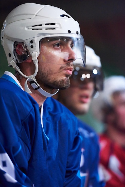 eishockeyspieler, gruppe von teamfreunden, die auf der bank warten, um das spiel zu beginnen