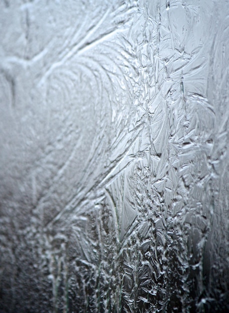 Eisiges Muster auf gefrorenem Fenster. Gefrorenes Wasser Textur.