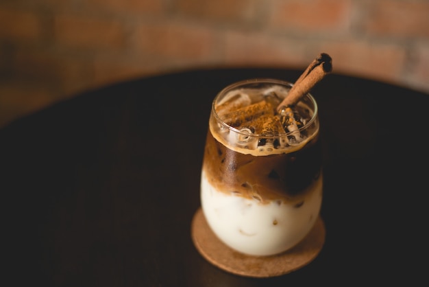 Eiskaffee auf einem Holztisch mit Backsteinmauerhintergrund