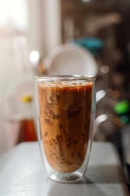 Eiskaffee auf einem Tisch mit Sahne, die hineingegossen wird und die Textur zeigt